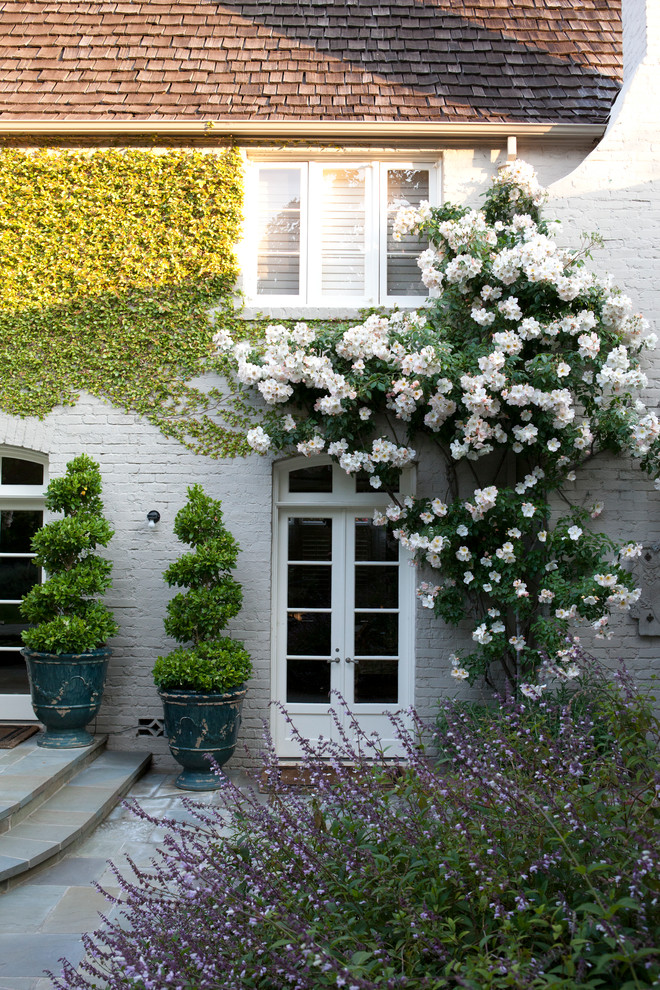 Ispirazione per un giardino formale tradizionale esposto in pieno sole di medie dimensioni e dietro casa con pavimentazioni in pietra naturale
