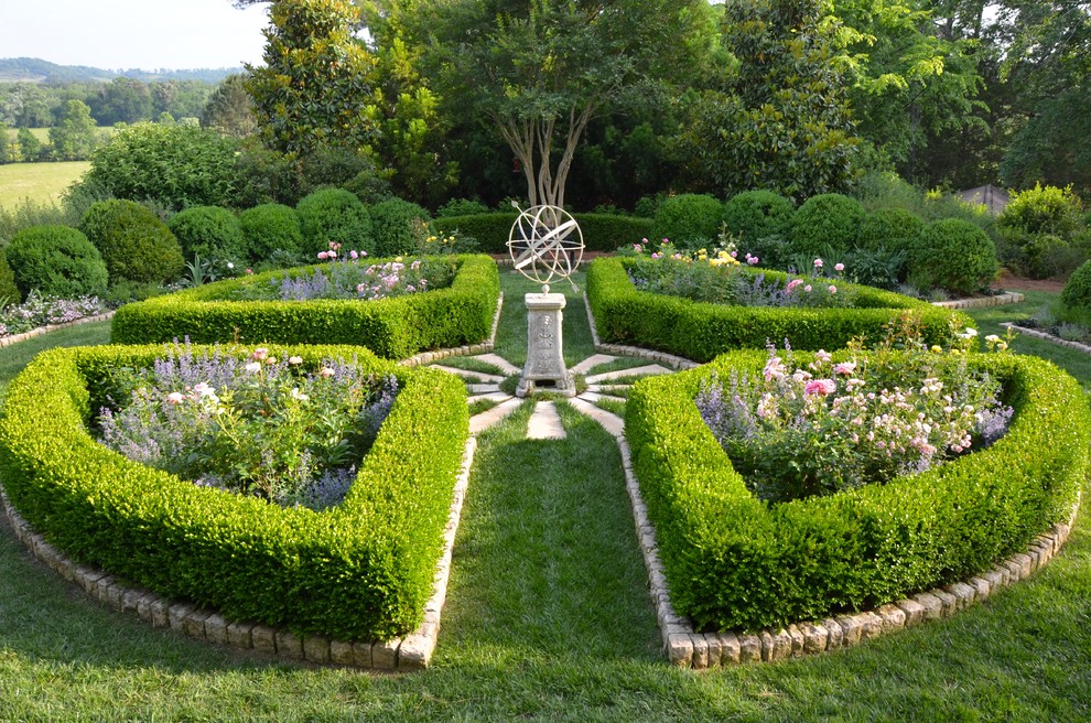 Imagen de jardín tradicional grande en primavera en patio lateral con jardín francés, exposición total al sol y adoquines de piedra natural
