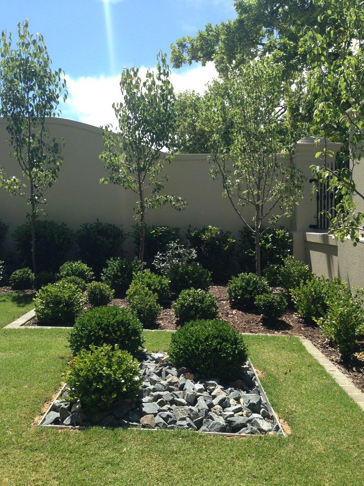 Immagine di un giardino formale chic esposto a mezz'ombra di medie dimensioni e davanti casa con pavimentazioni in pietra naturale