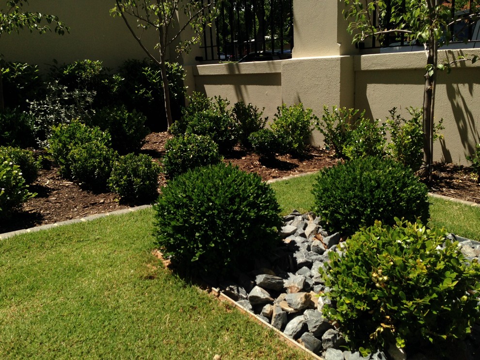 Foto di un giardino formale classico esposto a mezz'ombra di medie dimensioni e davanti casa con pavimentazioni in pietra naturale