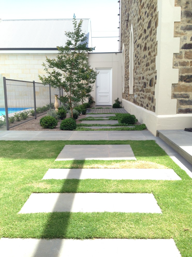 Idéer för att renovera en mellanstor vintage bakgård i delvis sol, med en trädgårdsgång och naturstensplattor