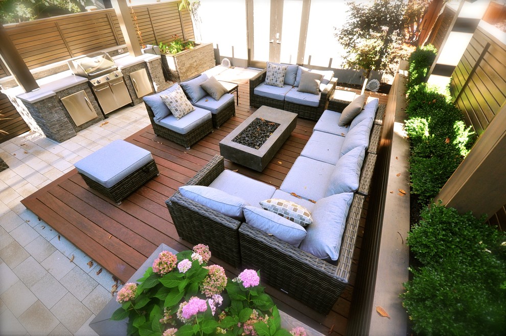 Photo of a small modern full sun backyard landscaping in Toronto with decking and a fire pit.