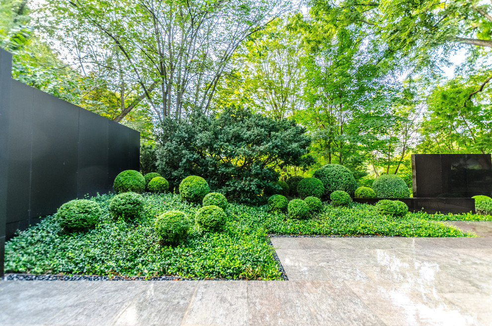 Idee per un giardino formale moderno esposto a mezz'ombra di medie dimensioni e dietro casa in estate con pavimentazioni in pietra naturale
