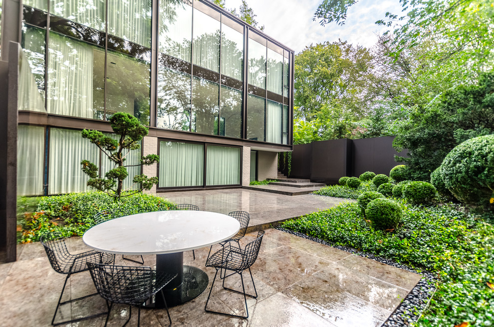 Ispirazione per un giardino formale moderno esposto a mezz'ombra di medie dimensioni e dietro casa in estate con pavimentazioni in pietra naturale