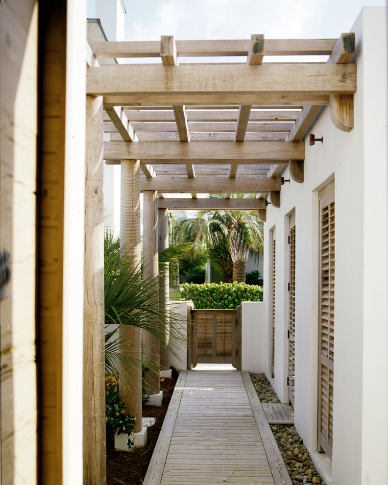 マイアミにある広いトロピカルスタイルのおしゃれな庭 (庭への小道、半日向、デッキ材舗装) の写真