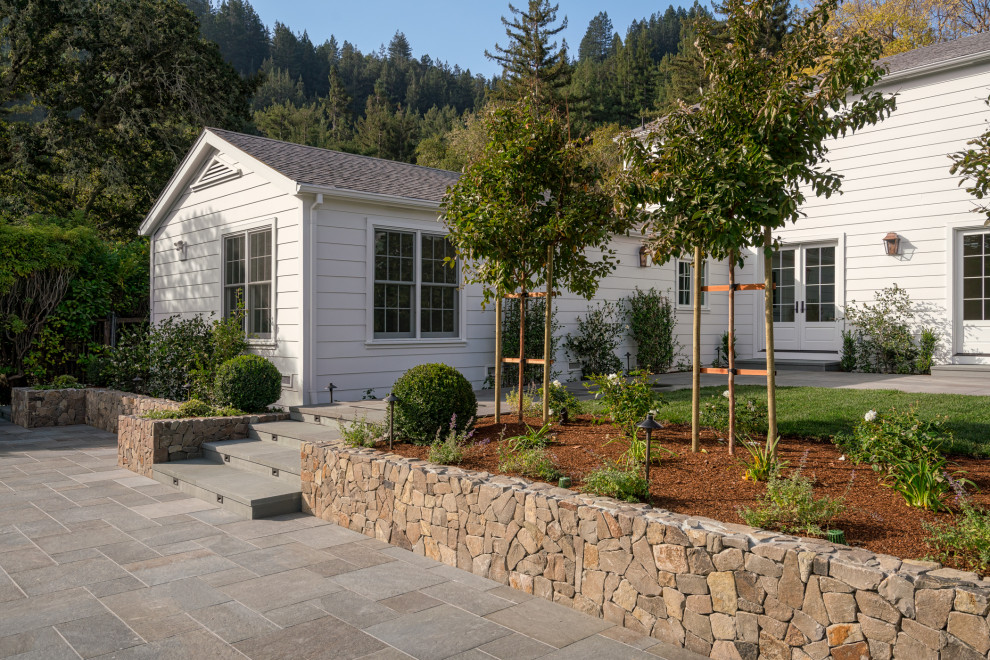 Photo of a large traditional partial sun backyard stone landscaping in San Francisco.
