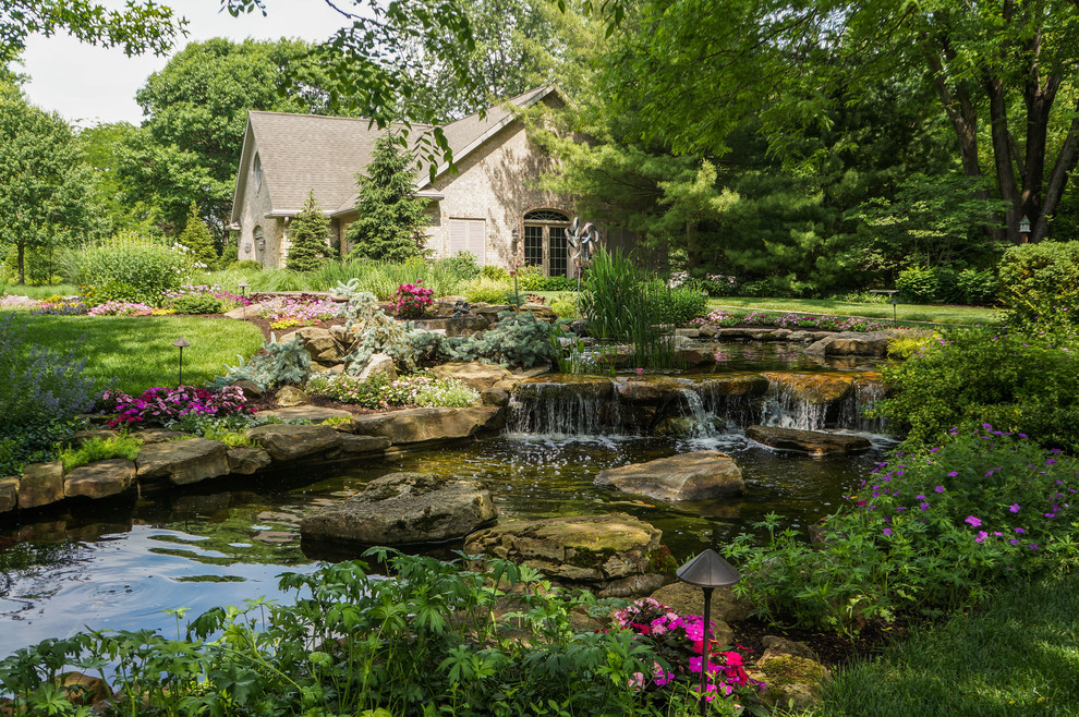 Modelo de jardín de estilo de casa de campo extra grande en primavera en ladera con fuente