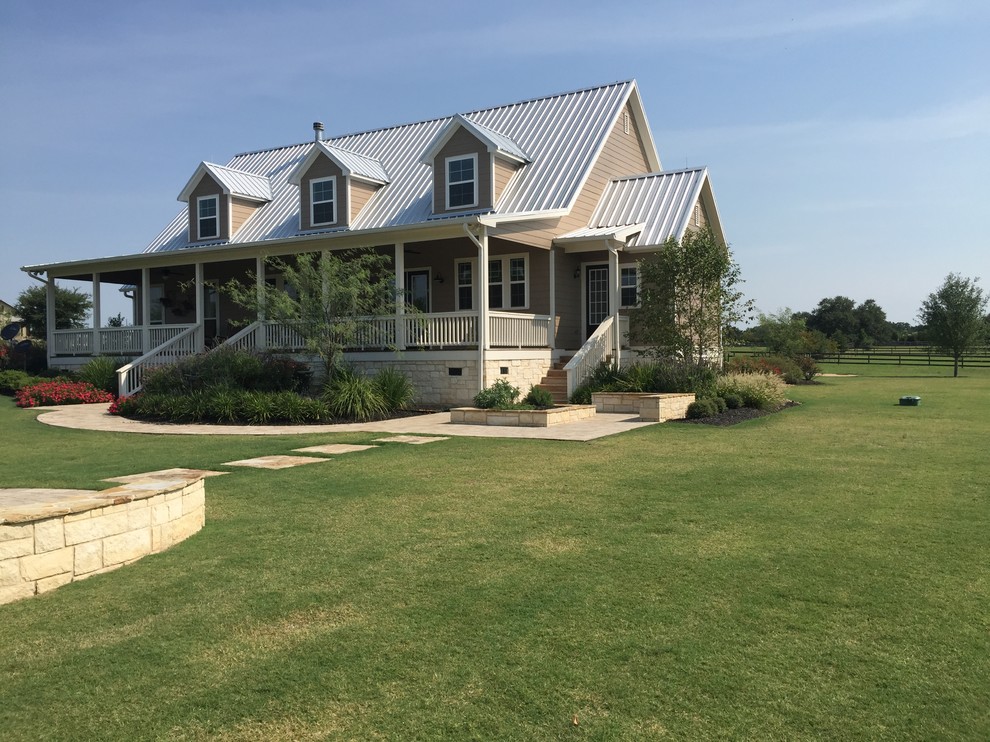 This is an example of a large farmhouse back driveway full sun garden for summer in Houston with a vegetable patch and natural stone paving.