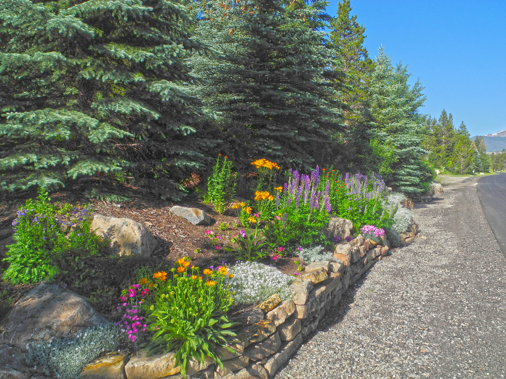 Photo of a rustic shade front yard stone retaining wall landscape in Denver for summer.