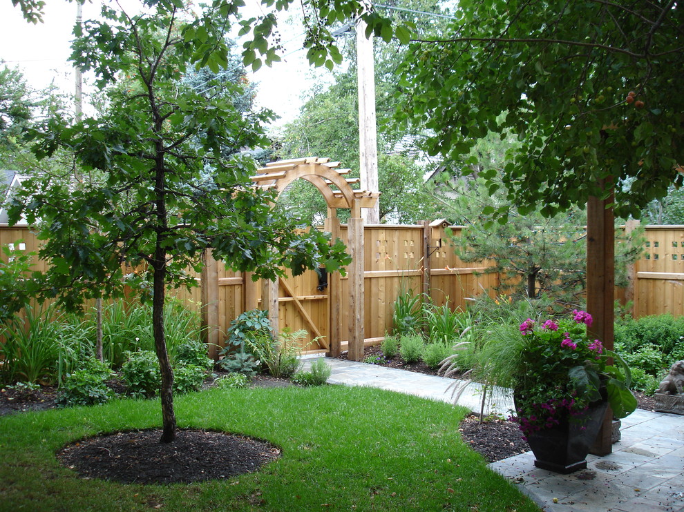 На фото: солнечный регулярный сад среднего размера на заднем дворе в стиле кантри с садовой дорожкой или калиткой, хорошей освещенностью и мощением тротуарной плиткой с