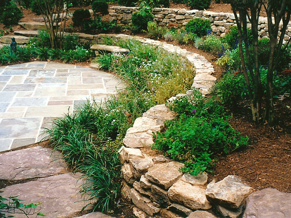 Idee per un giardino classico di medie dimensioni con un muro di contenimento, un pendio, una collina o una riva e pavimentazioni in pietra naturale