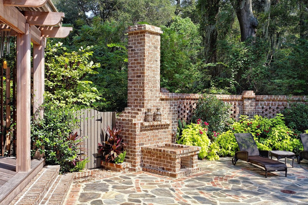 Cette image montre un grand jardin arrière traditionnel avec un foyer extérieur, une exposition partiellement ombragée et des pavés en brique.