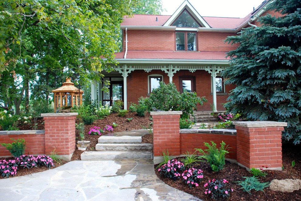 Foto di un giardino formale classico davanti casa con un ingresso o sentiero e pavimentazioni in pietra naturale