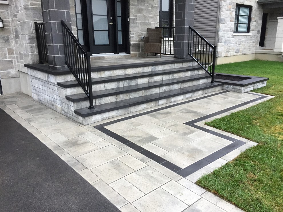 This is an example of a mid-sized modern front yard concrete paver driveway in Ottawa.