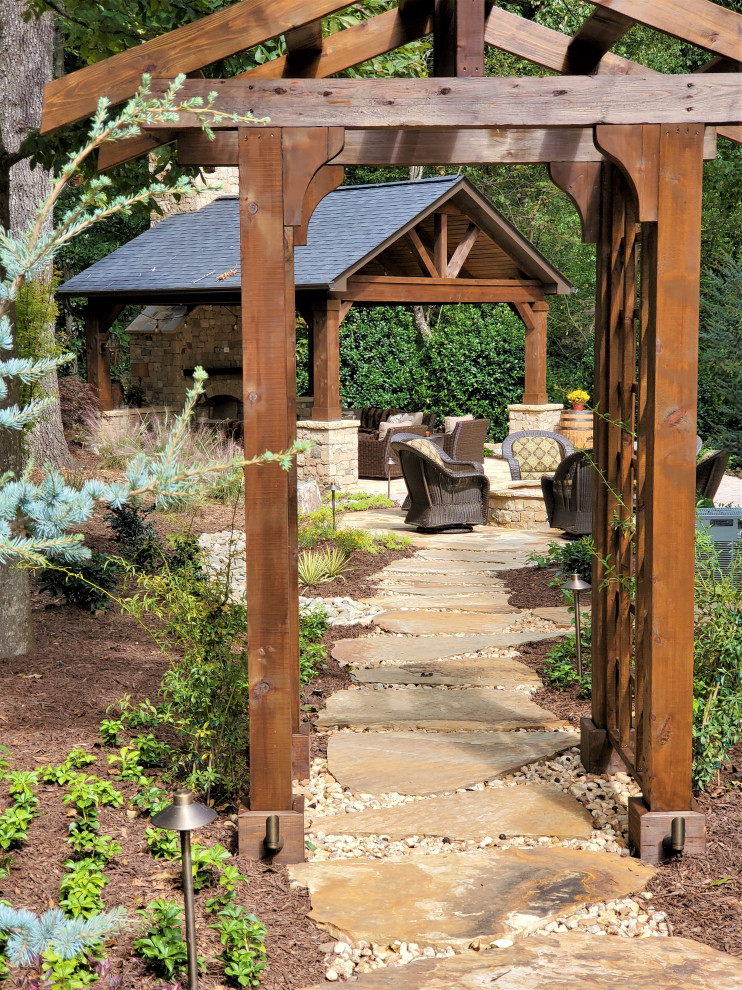 Esempio di un grande giardino stile rurale esposto a mezz'ombra dietro casa in estate con un ingresso o sentiero, pavimentazioni in pietra naturale e recinzione in legno