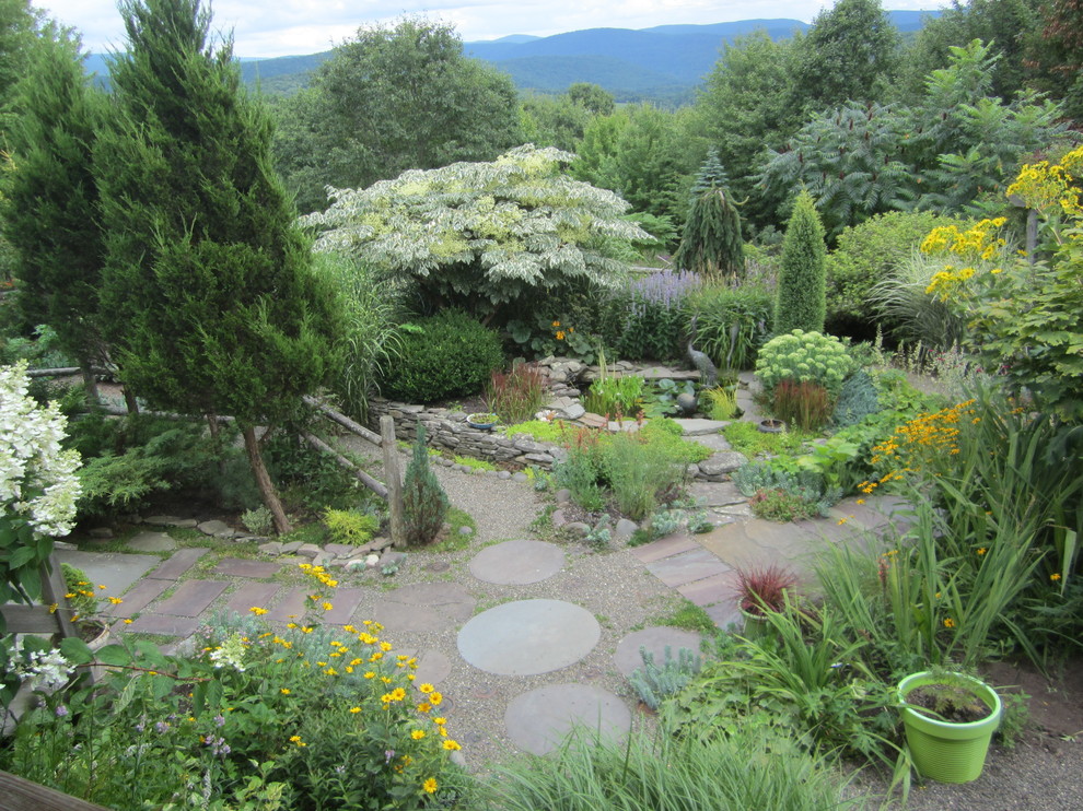 Aménagement d'un grand jardin arrière montagne avec un bassin, une exposition partiellement ombragée et des pavés en pierre naturelle.