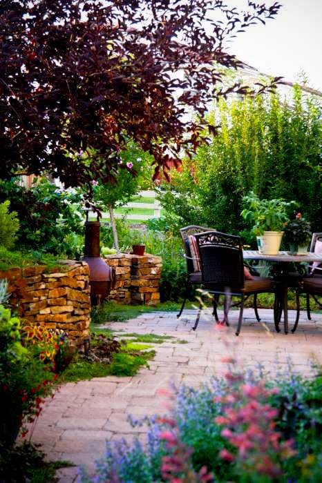Idee per un piccolo giardino stile rurale esposto a mezz'ombra dietro casa con un muro di contenimento e pavimentazioni in cemento