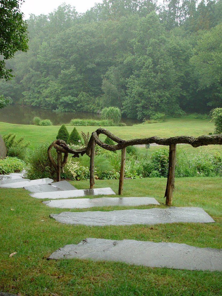 На фото: сад с прудом на заднем дворе в стиле рустика с покрытием из каменной брусчатки с