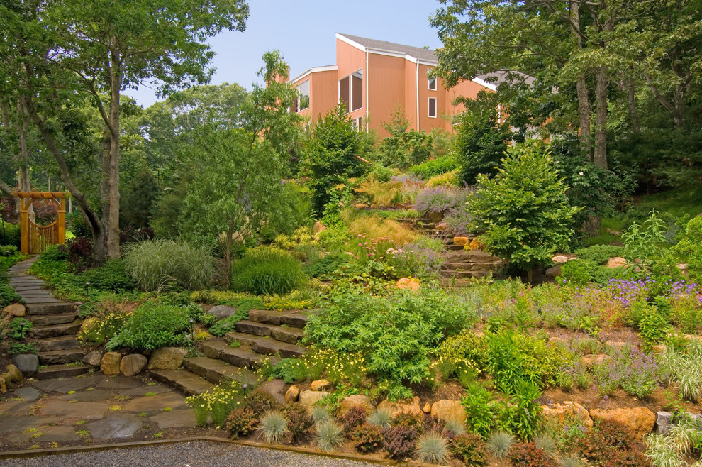 Immagine di un grande giardino rustico esposto a mezz'ombra davanti casa in estate con un ingresso o sentiero e pavimentazioni in pietra naturale