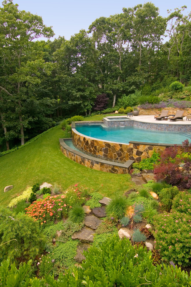 Idee per un grande giardino formale stile rurale esposto in pieno sole dietro casa in estate con un muro di contenimento e pavimentazioni in pietra naturale