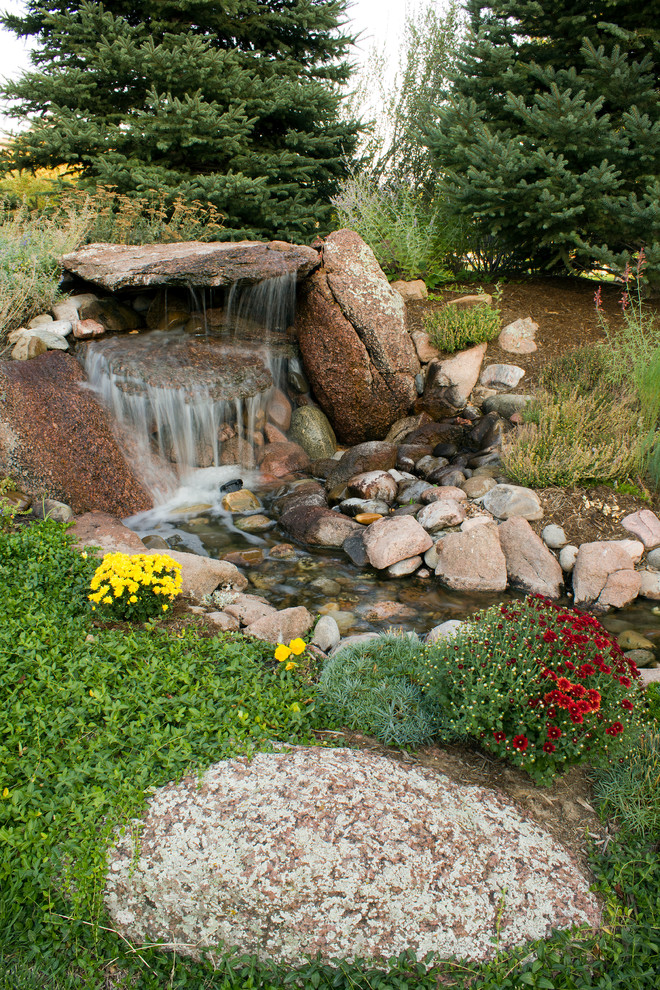Design ideas for a mid-sized rustic partial sun backyard gravel water fountain landscape in Denver.