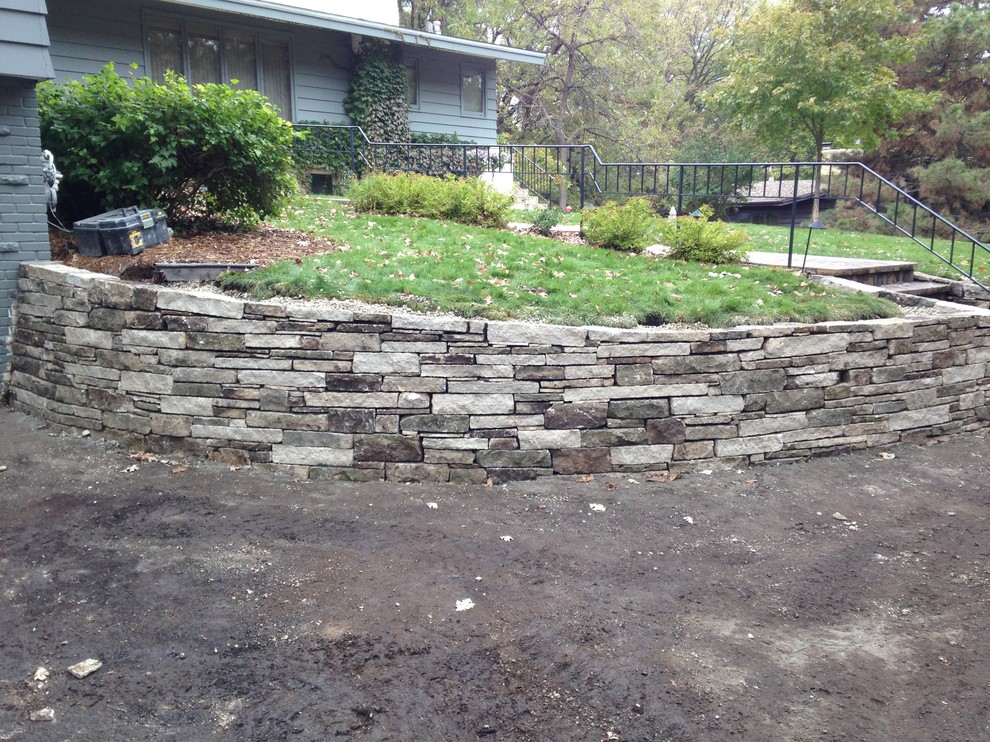 Inspiration for a mid-sized rustic front yard stone retaining wall landscape in Minneapolis.