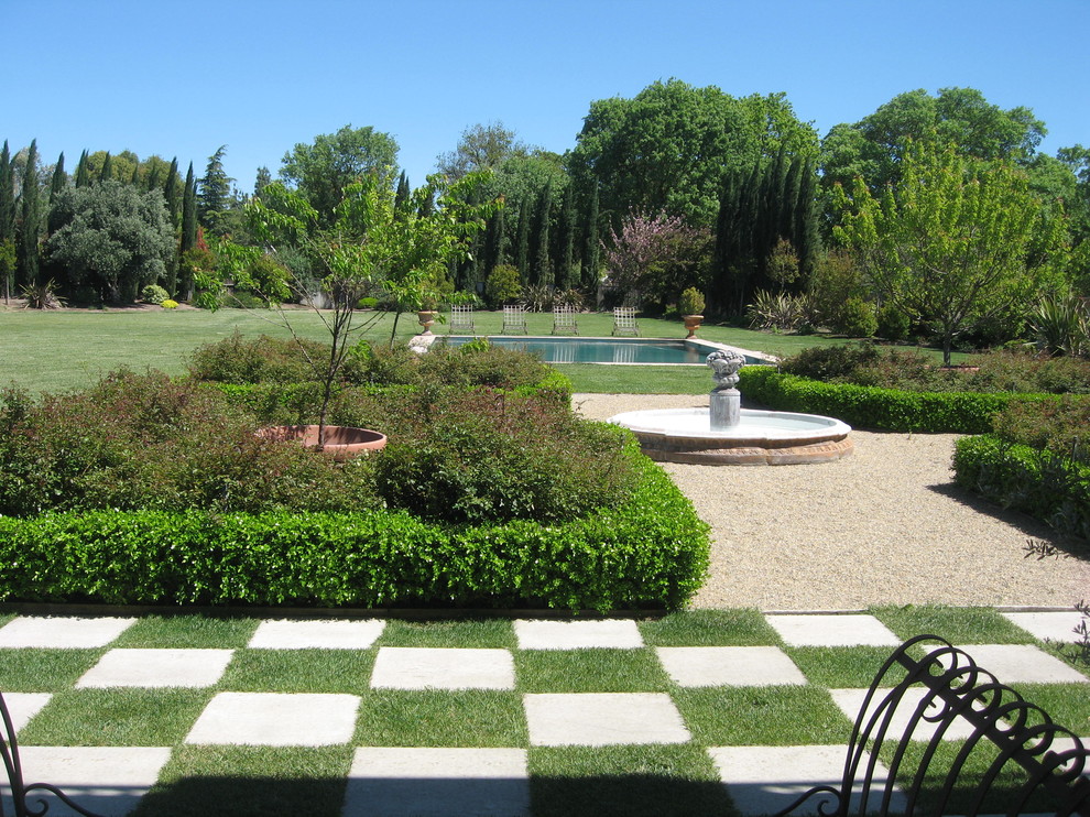 This is an example of a mediterranean back garden in Sacramento with a water feature.