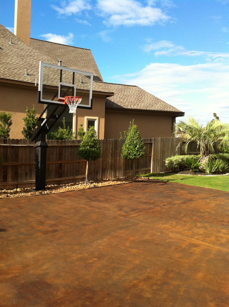 Large classic back partial sun garden in Houston with an outdoor sport court.