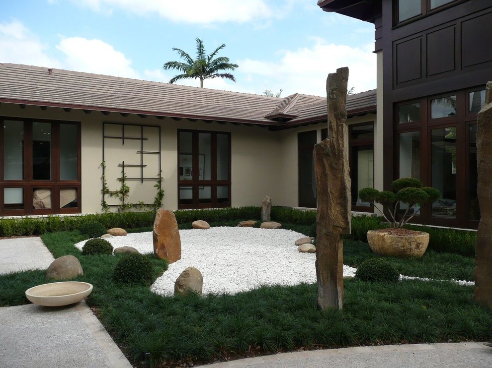 Diseño de acceso privado asiático grande en patio delantero con adoquines de hormigón