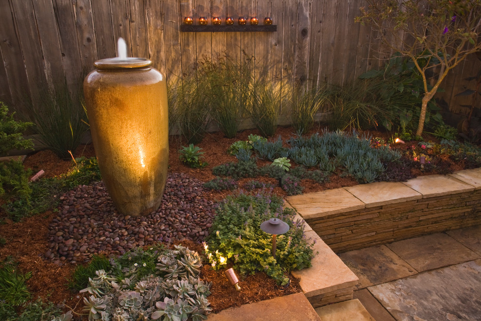 Photo of a medium sized mediterranean back xeriscape partial sun garden in San Francisco with a water feature and mulch.