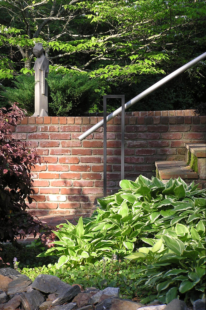 Aménagement d'un petit jardin à la française arrière contemporain au printemps avec une exposition partiellement ombragée et des pavés en brique.