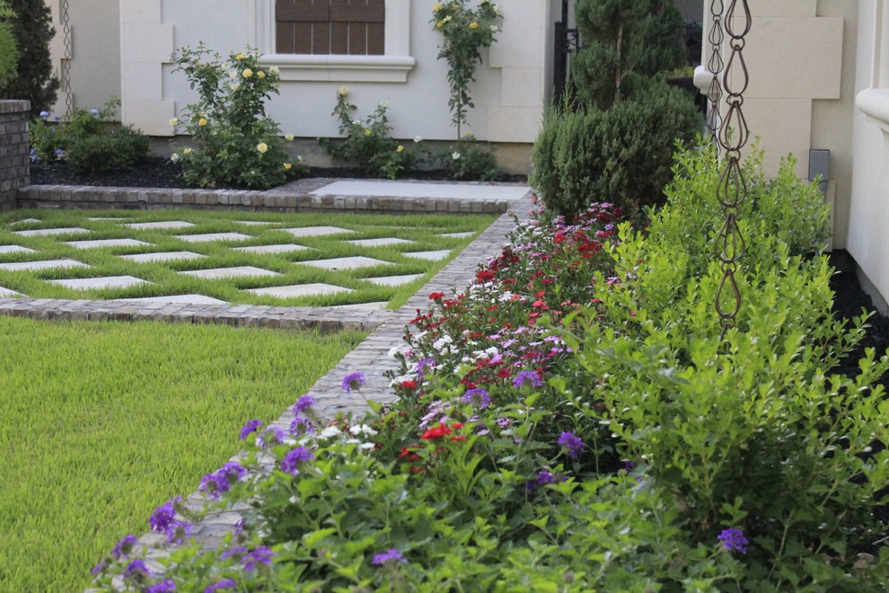 Imagen de camino de jardín clásico en patio delantero con adoquines de hormigón