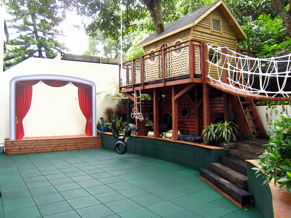Idee per un grande giardino formale tropicale in ombra dietro casa in primavera con uno spazio giochi e pacciame