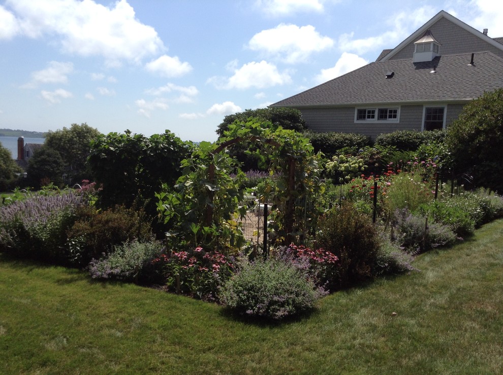 This is an example of a mid-sized full sun hillside gravel landscaping in Providence.