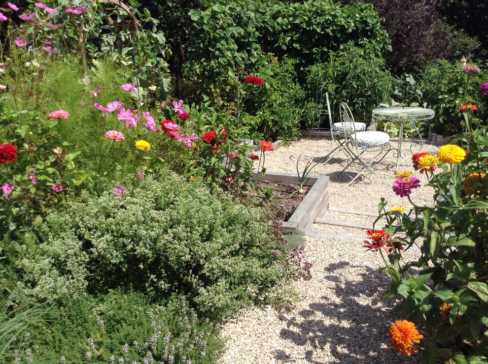 Immagine di un giardino esposto in pieno sole di medie dimensioni in estate con un pendio, una collina o una riva e ghiaia