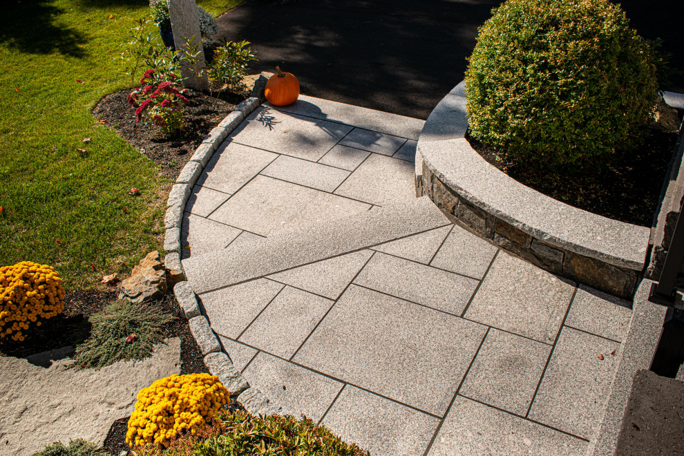 This is an example of a coastal front full sun garden in Portland Maine with a pathway and natural stone paving.