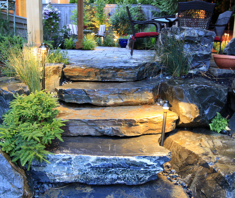 Diseño de jardín clásico de tamaño medio en patio trasero con adoquines de piedra natural