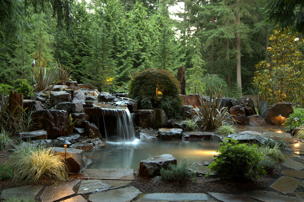 Esempio di un giardino design di medie dimensioni e dietro casa con fontane e pavimentazioni in pietra naturale