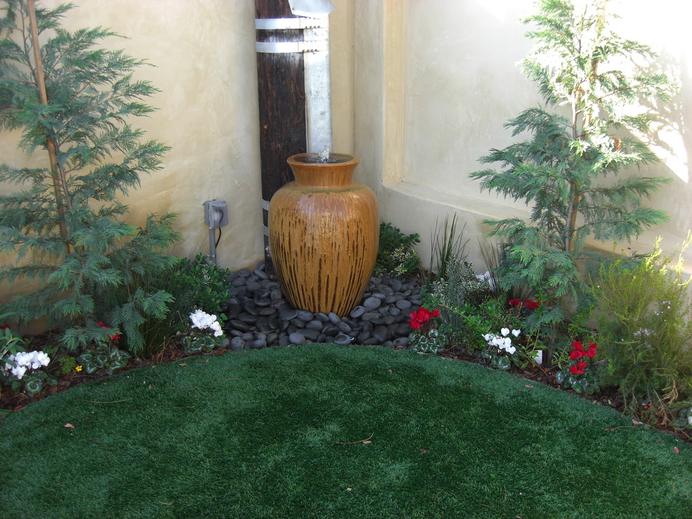 Exemple d'un jardin latéral tendance de taille moyenne avec un point d'eau, une exposition partiellement ombragée et un paillis.