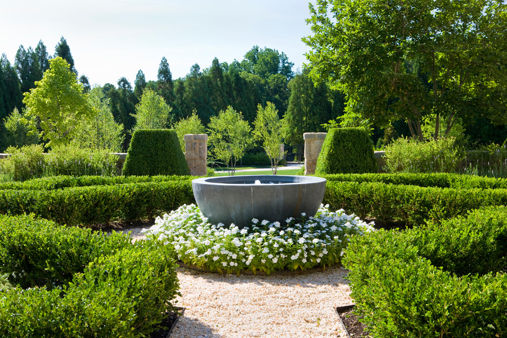 Diseño de jardín tradicional con fuente y gravilla