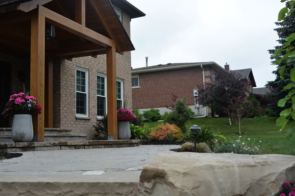 Immagine di un giardino formale stile americano esposto in pieno sole di medie dimensioni e davanti casa con un ingresso o sentiero e pavimentazioni in pietra naturale
