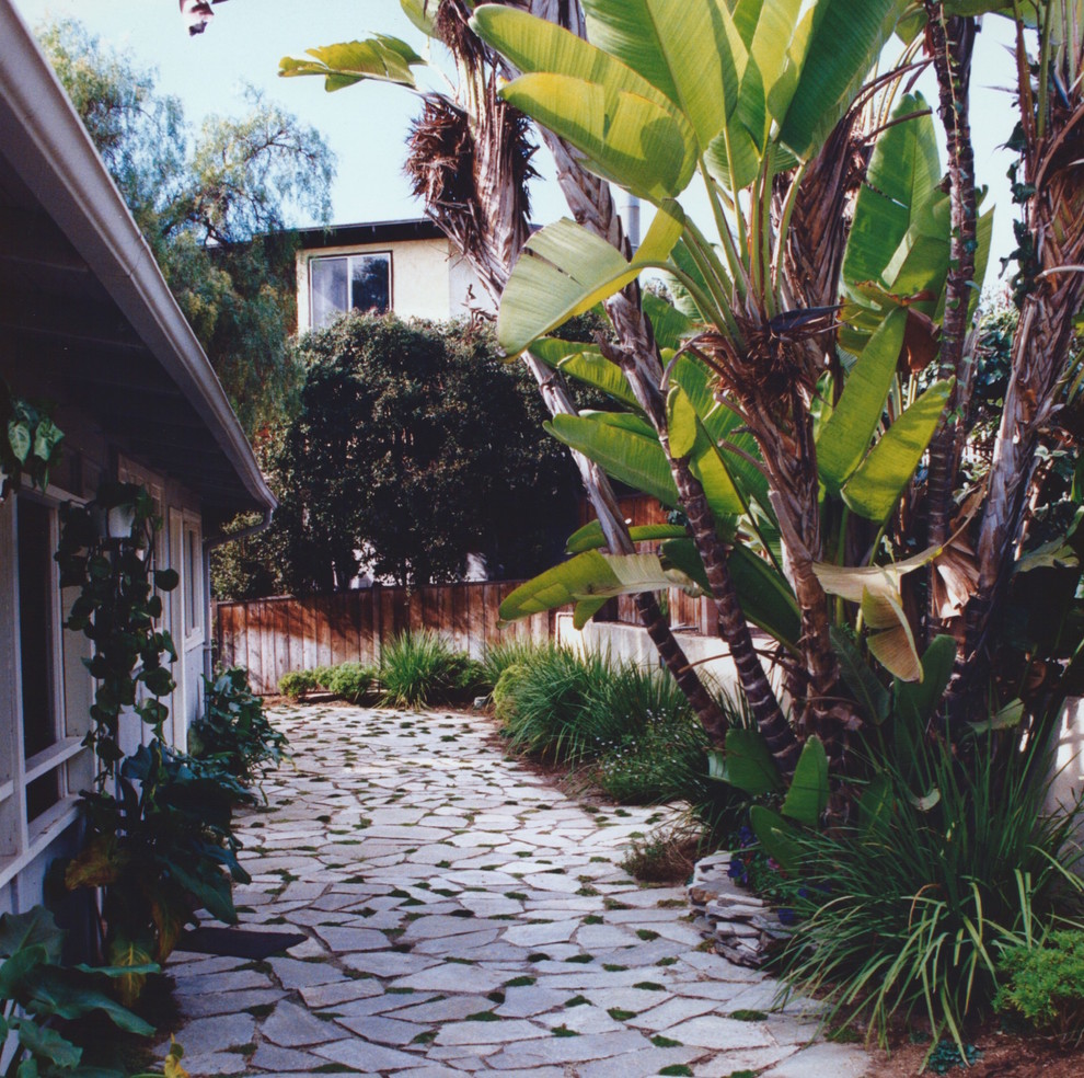 Imagen de jardín tradicional de tamaño medio en verano en patio trasero con exposición total al sol y adoquines de piedra natural