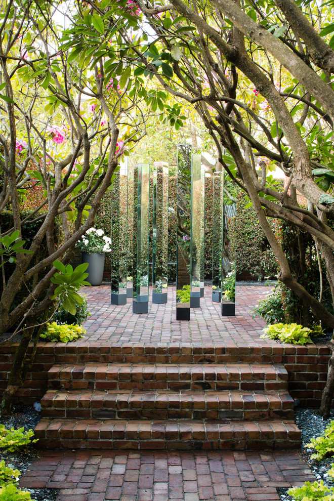 Foto di un giardino moderno esposto a mezz'ombra di medie dimensioni con un ingresso o sentiero e pavimentazioni in mattoni