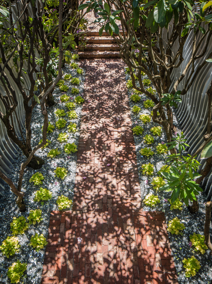 Foto di un giardino minimalista esposto a mezz'ombra di medie dimensioni con un ingresso o sentiero e pavimentazioni in mattoni