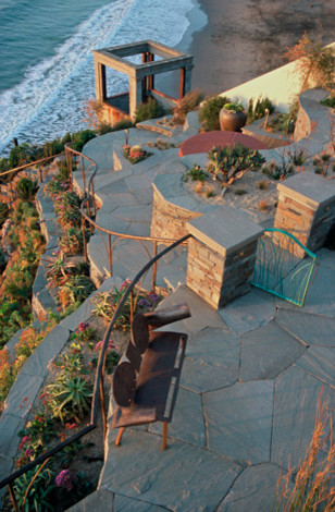 Esempio di un giardino xeriscape stile marino esposto in pieno sole di medie dimensioni in inverno con un pendio, una collina o una riva, pavimentazioni in pietra naturale e un ingresso o sentiero