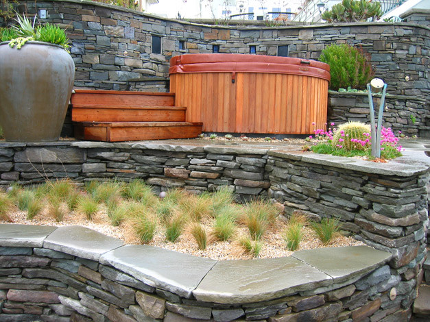Idee per un giardino xeriscape stile marinaro esposto in pieno sole di medie dimensioni in inverno con un muro di contenimento, un pendio, una collina o una riva e pavimentazioni in pietra naturale
