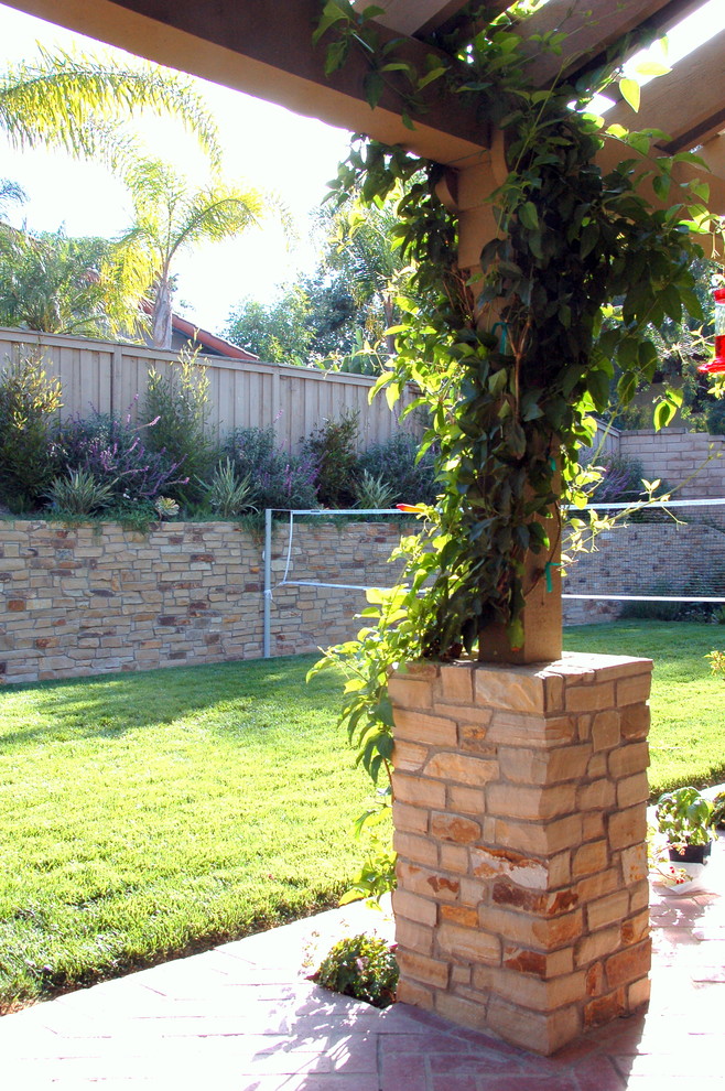 Cette photo montre un jardin arrière craftsman avec une exposition ensoleillée et des pavés en brique.