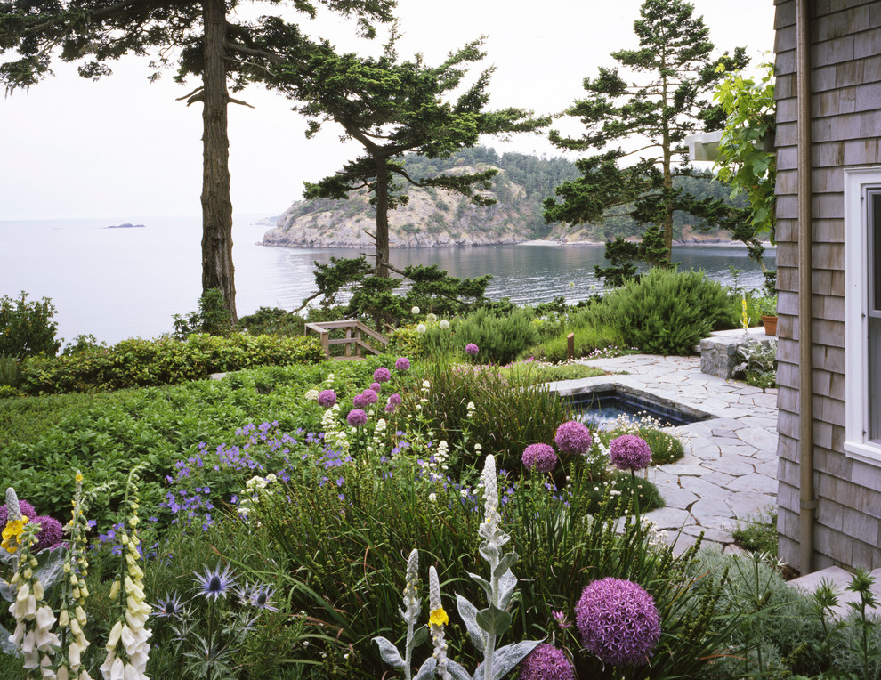 Maritimer Garten im Sommer, hinter dem Haus mit Wasserspiel und Natursteinplatten in Seattle