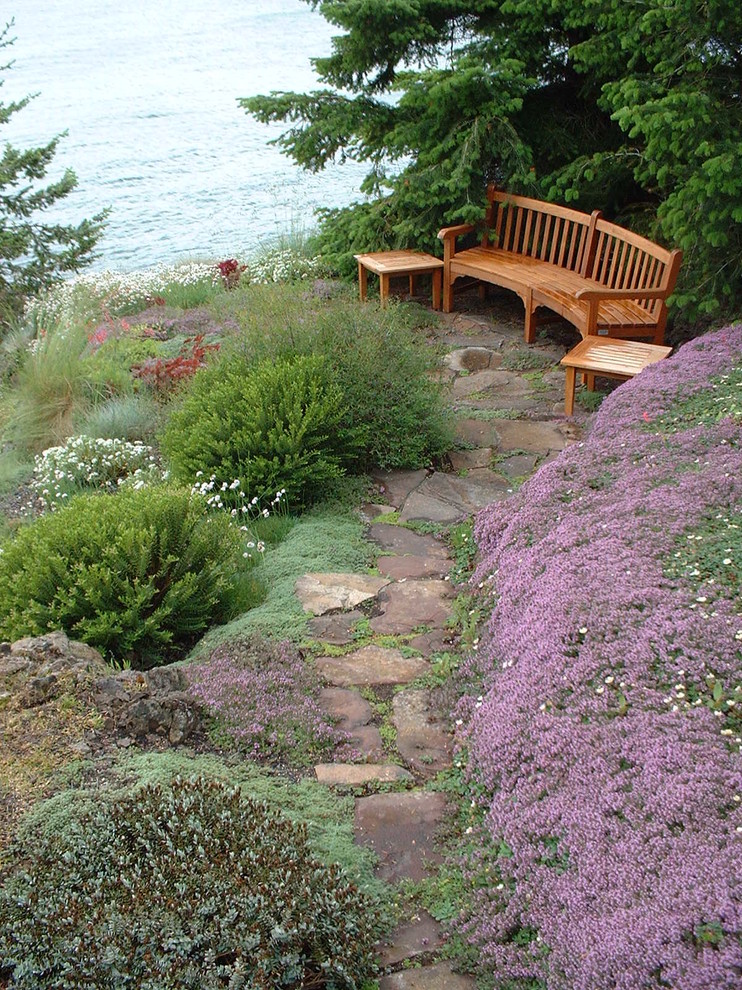 Diseño de jardín costero en ladera con adoquines de piedra natural