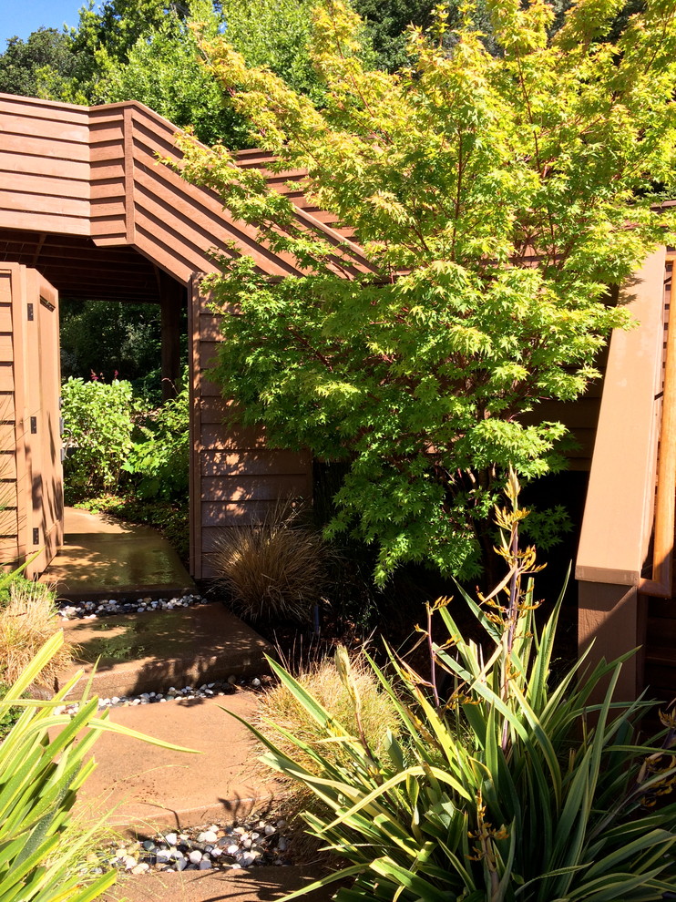 Foto de jardín tradicional de tamaño medio en primavera en patio delantero con exposición total al sol y adoquines de hormigón